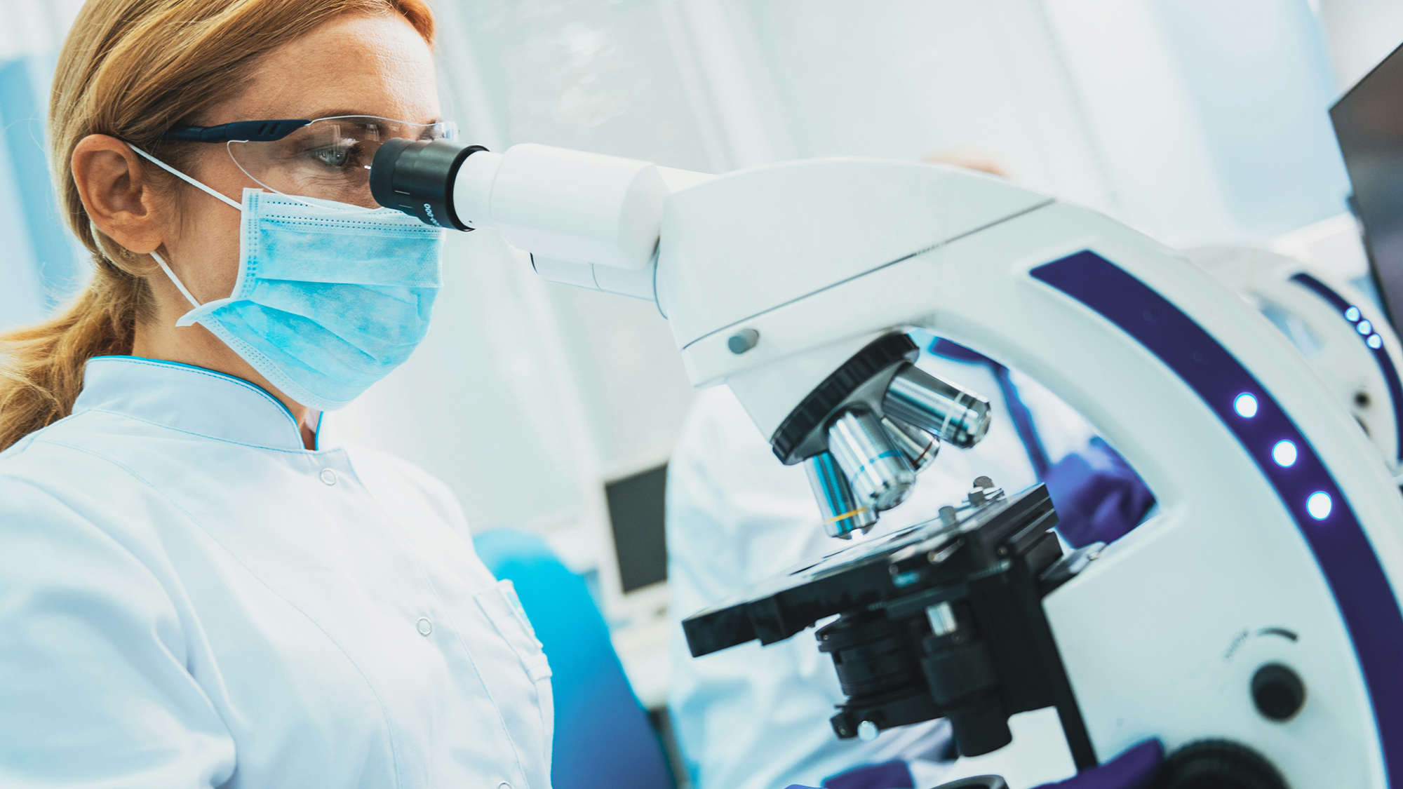 Woman scientist looking through a microscope